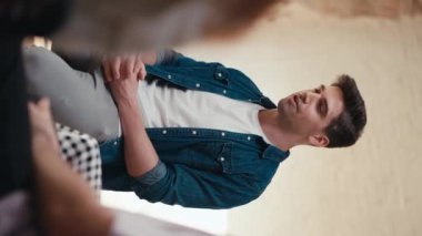 Dikey video: Mavi kot ceketli ve beyaz tişörtlü esmer bir adam grup terapisine katılanlara bakış açısını anlatıyor. Fikirlerini ifade etmek ve grup terapisi sırasında kendini tanıtmak.