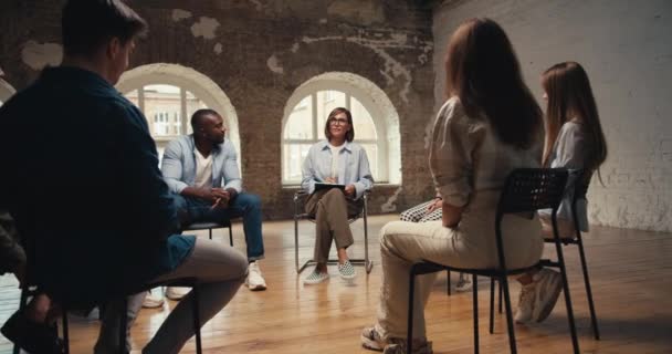 Egy Női Pszichológus Szemüvegben Bob Frizurával Befejezi Csoportterápiát Résztvevői Felállnak — Stock videók