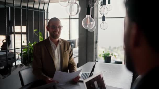 近代的なオフィスでのインタビューのためのライトブラウンワーカーのブロンド男 現代オフィスのインタビューのためのひげとメガネを持つ幸せなブロンドの男 — ストック動画