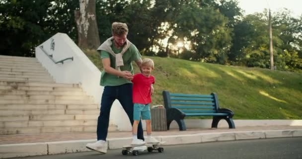 Seorang Ayah Dengan Kaos Hijau Dengan Rambut Keriting Mengajarkan Anaknya — Stok Video
