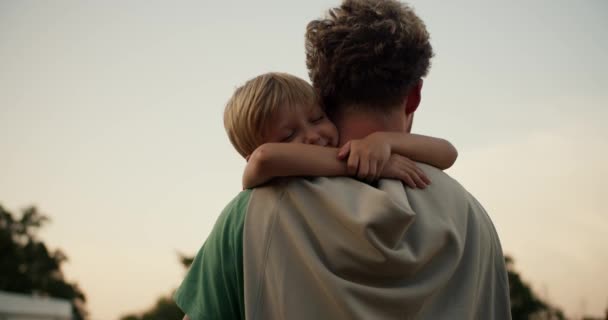Menino Louro Amorosamente Abraça Pescoço Seu Pai Com Cabelo Encaracolado — Vídeo de Stock