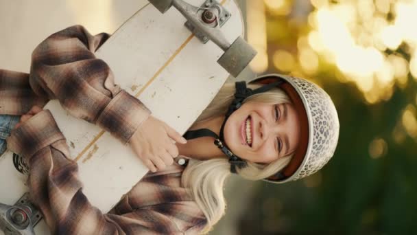 Вертикальне Відео Портрет Щасливої Блондинки Яка Тримає Скейтборд Руках Одягнена — стокове відео