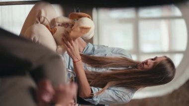 Mavi tişörtlü, elinde yumuşak bir oyuncakla grup terapisindeki probleminden bahseden uzun saçlı bir kızın dikey videosu. Grup terapisinin geri kalanı kızı destekliyor.