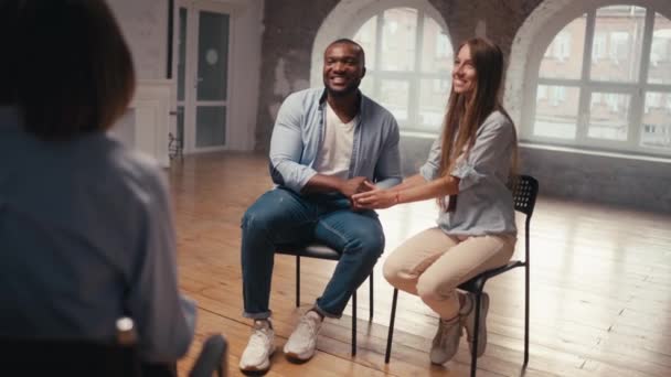 快乐适合的男人与黑色皮肤的颜色和短发与他的女朋友长发感谢心理学家的联合治疗 夫妇集体治疗的快乐结局 — 图库视频影像