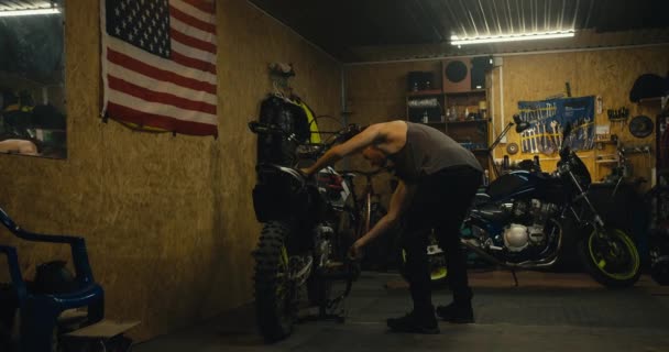 Ένας Άντρας Μηχανικός Κοντό Κούρεμα Και Γκρι Μπλουζάκι Βάζει Ποδήλατό — Αρχείο Βίντεο