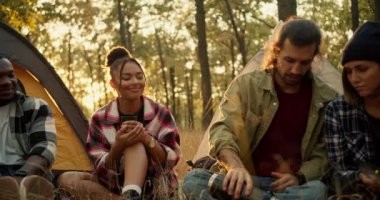 Kareli gömleklerle yürüyüş yapan ve bardaklara çay dolduran yürüyüş yapan mutlu bir grup insanın yakın plan fotoğrafı. Duraklama sırasında termos kullanarak...