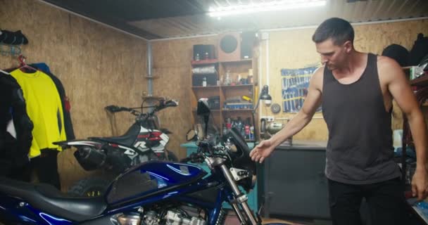 Мужчина Механик Серой Рубашке Осматривает Синий Мотоцикл Гаражной Мастерской Работа — стоковое видео