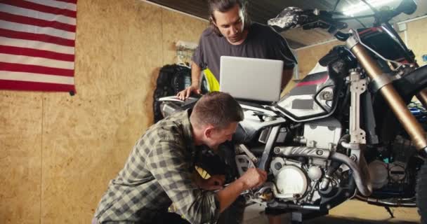 Dos Mecánicos Están Desmontando Inspeccionando Una Motocicleta Tipo Con Una — Vídeos de Stock