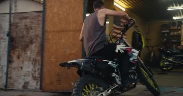 Ein Männlicher Motorradfahrer Mit Kurzhaarschnitt Und Grauem Tanktop Rollt Sein — Stockvideo