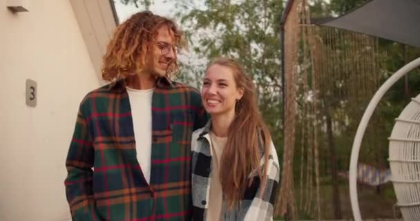 一个穿着格子衬衫的卷发男人正在和他的女朋友在外面聊天和散步 在乡间别墅休息 — 图库视频影像