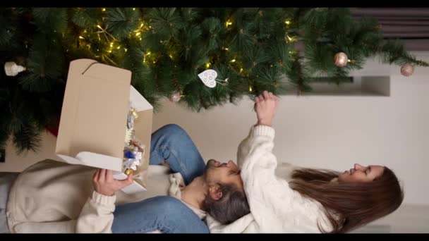 비디오 크리스마스 장식과 상자에서 장식을 복용하고 크리스마스 트리에 부착하는 소녀와 — 비디오