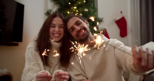 초상화 남자와 스웨터에 카메라를 미소와 빛나는 그들의 스파클러를 근처의 분위기에서 — 비디오