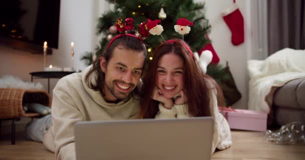 남자와 아늑한 장식된 방에서 크리스마스 크리스마스 영화를 노트북 바닥에 — 비디오