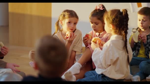 Anaokulu Çocukları Özel Yastıklarda Yere Oturur Molada Elma Muz Yerler — Stok video