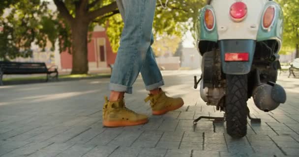 Nahaufnahme Läuft Ein Mann Jeanshose Seinem Grünen Moped Setzt Sich — Stockvideo