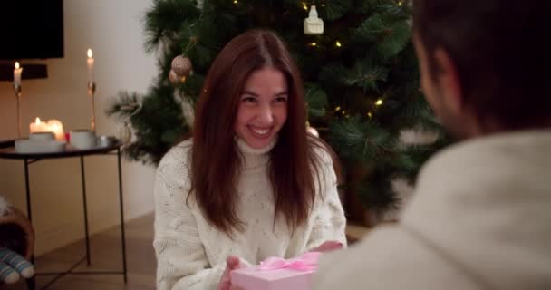 Válla Fölött Egy Srác Ajándékot Barna Barátnőjének Fehér Karácsonyi Pulóverben — Stock videók
