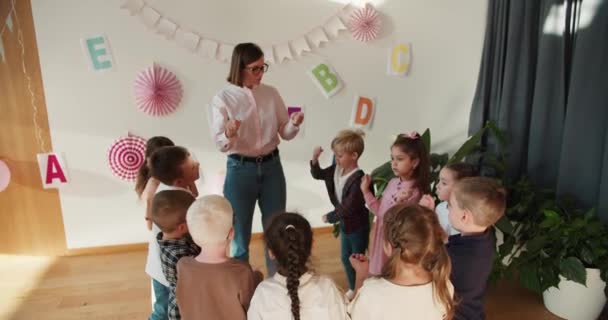 선생님과 따뜻하게하는 그룹에서 행복한 유치원 아이들 어린이를위한 특별한 클럽에서 셔츠에 — 비디오