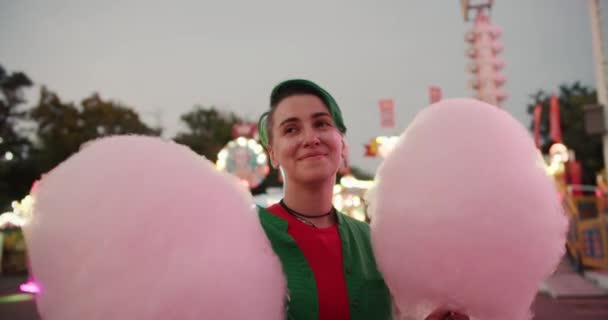 一个绿色短发的女同志走进一家皮卡 手里拿着两块粉红色的棉花糖 — 图库视频影像