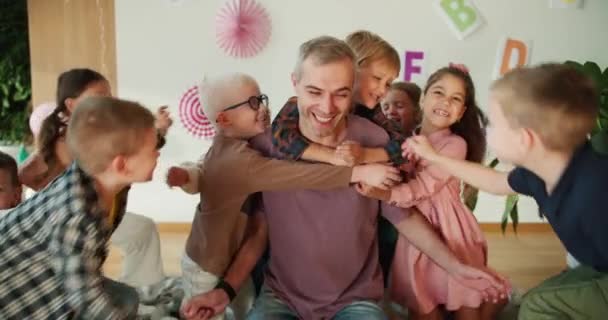 Een Groep Kinderen Knuffelt Hun Leraar Een Man Met Grijs — Stockvideo