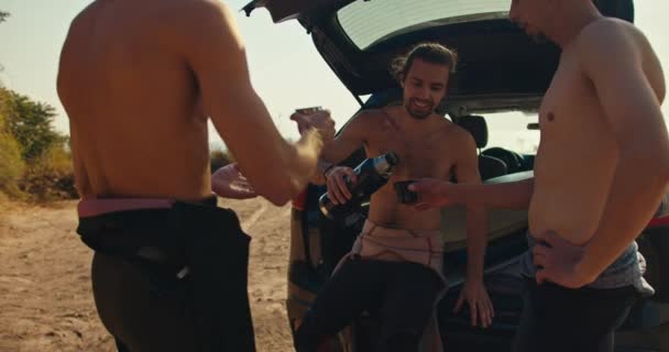 Three Surfers Naked Monitors Wetsuits Drink Tea Thermos Surfing Three — Stock Video