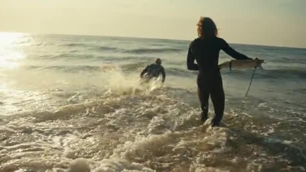 Två Män Våtdräkt Med Surfbrädor Går Havet Och Rider Vågorna — Stockvideo