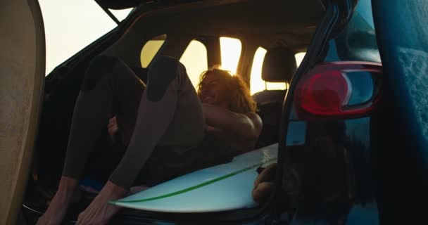 Facet Kręconymi Włosami Leży Bagażniku Samochodu Próbuje Założyć Kombinezon Pływać — Wideo stockowe