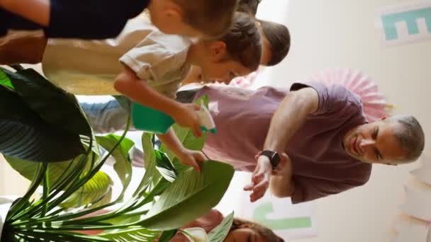 Вертикальне Відео Чоловіка Сірим Волоссям Фіолетовій Футболці Навчає Дітей Дошкільного — стокове відео