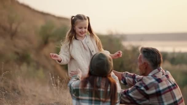 Beyaz Ceketli Mutlu Küçük Sarışın Bir Kız Ailesine Koşar Üzerlerine — Stok video