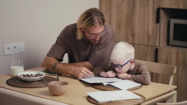 Счастливого Альбиноса Белыми Волосами Круглых Синих Очках Учат Читать Писать — стоковое видео
