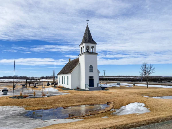 An old country church with elegant bell tower sits on the quiet plains
