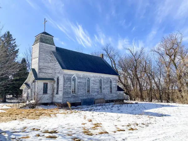 An old country church sits on a beautiful winter landscape