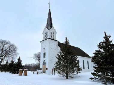 Bu eski taşra kilisesinin etrafında yeni bir sabah doğuyor karın üzerinde oturuyor.