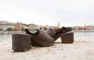 Budapeşte, Macaristan - 22 Ekim 2022: Tuna kıyısında ayakkabılar. Macaristan 'ın Budapeşte kentindeki Tuna Nehri kıyısındaki İkinci Dünya Savaşı sırasında yaşanan soykırım kurbanlarının anısına dikilen anıt..