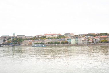 Budapeşte, Macaristan - 22 Ekim 2022: Bulutlu bir günde Tuna Nehri üzerinde turistlerle seyahat gemileri
