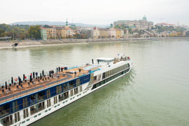 Budapeşte, Macaristan - 22 Ekim 2022: Bulutlu bir günde Tuna Nehri üzerinde turistlerle seyahat gemileri