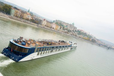 Budapeşte, Macaristan - 22 Ekim 2022: Bulutlu bir günde Tuna Nehri üzerinde turistlerle seyahat gemileri