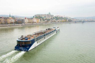 Budapeşte, Macaristan - 22 Ekim 2022: Bulutlu bir günde Tuna Nehri üzerinde turistlerle seyahat gemileri