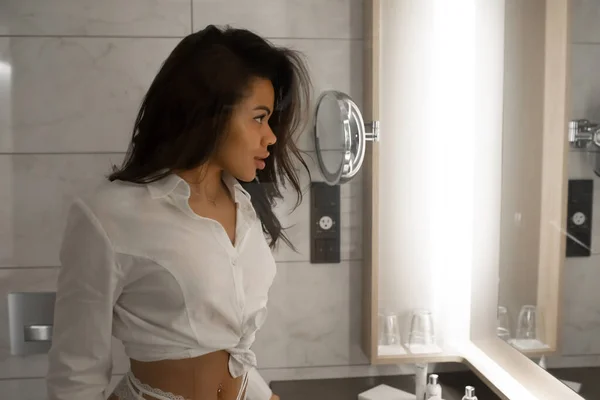 아름다운 아가씨 욕실에서 거울을 들여다보고 있습니다 — 스톡 사진