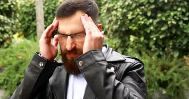 Başı ağrıyan, yorgun ve üzgün sakallı bir adam.. 