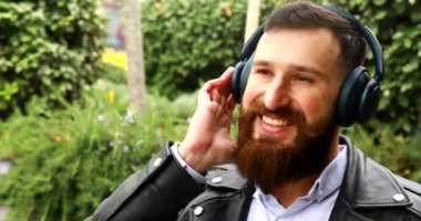 Kulaklıklı yakışıklı adam dışarıda müzik dinliyor.. 