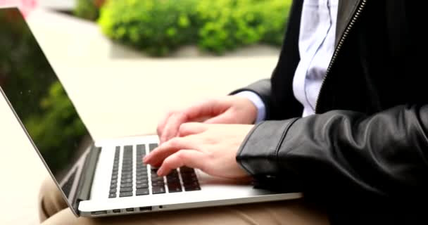 男性在笔记本电脑上打字 男性自由职业者坐在户外远程工作 学生使用计算机技术在网上学习或工作 — 图库视频影像