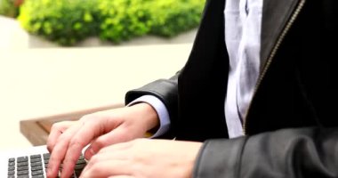 Yakın çekim erkek elleri dizüstü bilgisayarda yazıyor, serbest çalışan bir adam dışarıda uzaktan çalışıyor, bilgisayar teknolojisiyle çalışıyor ya da çevrimiçi çalışıyor..