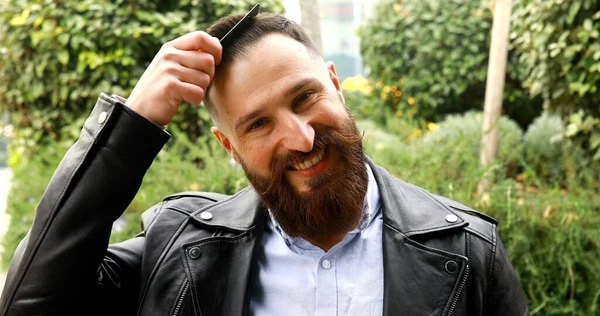 Портрет Красивого Бородатого Молодого Человека Кожаной Куртке Расчесывающего Волосы Парке — стоковое фото
