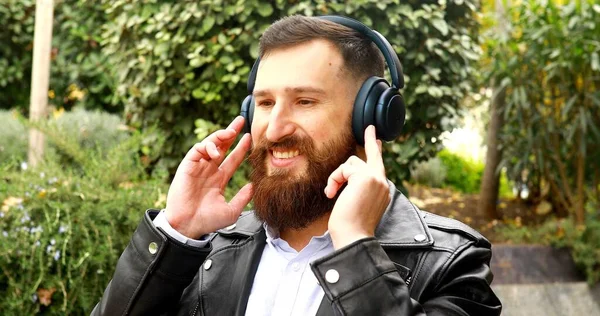 一个戴耳机的英俊男人在室外听音乐 — 图库照片