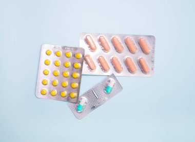 close-up view of scattered blister packs with different pills on blue background