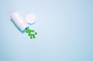 Medicine bottle and pills spilled on a light blue background. Medicines and prescription pills background 