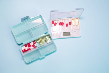 Plastic boxes with different pills on light blue background