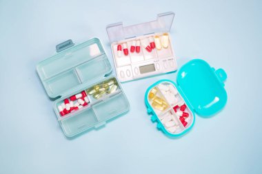 Plastic boxes with different pills on light blue background