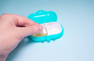 Senior woman organizing medication into pill dispenser. Senior woman taking pills from box. Healthcare and old age concept with medicines.