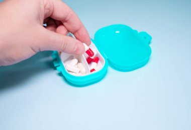 Senior woman organizing medication into pill dispenser. Senior woman taking pills from box. Healthcare and old age concept with medicines.